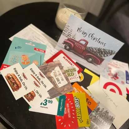 Gift cards for food, stores and haircuts beside a Christmas card